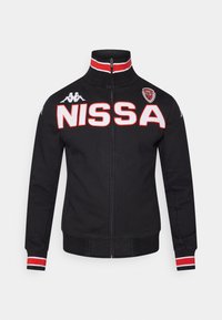 Svart zip-up jacka med röda och vita accenter, med "NISSA" i fetstil, Kappa-logotyp på bröstet och randiga muddar.