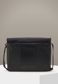 Borsa a tracolla nera in pelle con una texture liscia, patta superiore arrotondata, tracolla regolabile e design pulito e minimalista.