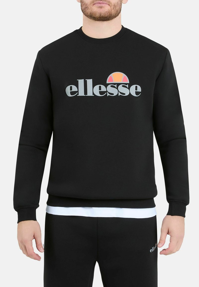 Felpa nera in misto cotone, con colletto a girocollo e polsini a coste. Presenta il logo "ellesse" e un design circolare colorato.