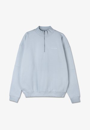 Soehe sinine dressipluus kõrge kaeluse ja poolnatukesega. Valmistatud pehmest kangast, omab soonikuid mansetides ja allservas ning rinda peene logoga.