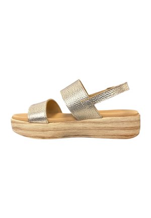 Sleehak met metallic gouden bandjes, open teen en plateauzool met houtstructuur, voorzien van een hielband voor extra steun.