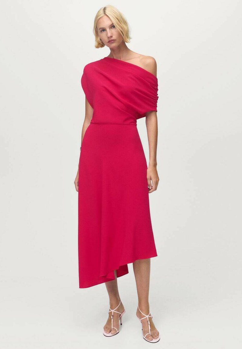 Vestido rojo fuera del hombro con textura drapeada, dobladillo asimétrico y cintura ajustada. Combinado con sandalias rosas con tiras.