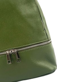 Groene leren tas met een gestructureerd oppervlak, zilveren ritsaccessoires en een gestructureerde vorm met een ronde basis.