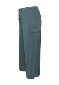 Lätta, vida byxor i teal-tyg. Har en elastisk midja med dragsko och en sidokargo-ficka. Mjuk textur.