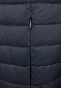 Tessuto imbottito nero con cuciture orizzontali e una linguetta di zip centrata.