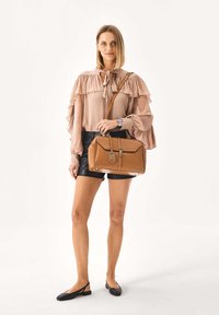 Brown leather handbag with gold hardware, rectangular shape and top handle, featuring a zip closure and a removable shoulder strap.