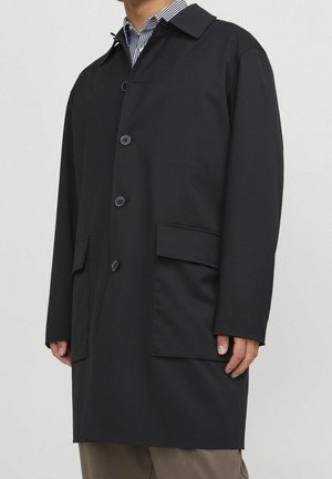 Schwarzer wasserdichter Trenchcoat mit einem Standardkragen, vorderen Knöpfen, seitlichen Taschen und geradem Schnitt. Hergestellt aus glattem, strapazierfähigem Material.