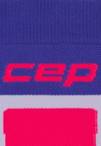 Calzino lavorato a maglia in viola e rosa con la scritta in grassetto "cep" in rosa su uno sfondo a fantasia, con una superficie liscia e punta rinforzata.