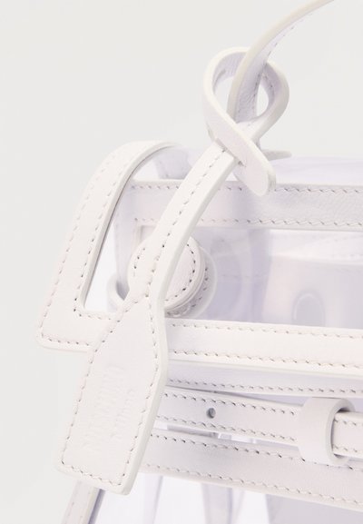 Λευκή δερμάτινη τσάντα με εμφανείς ραφές, διαφανή πλαστικά πάνελ, ρυθμιζόμενο λουρί και δερμάτινη ετικέτα σε βρόχο προσαρτημένη κοντά στη λαβή.