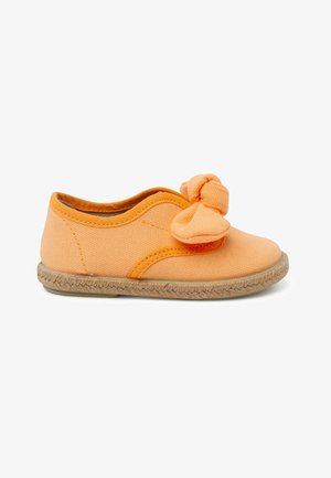 Scarpa slip-on in tela arancione con dettaglio a fiocco annodato, suola in juta e tomaia testurizzata. Presenta un design semplice e curvo con dettagli cuciti.