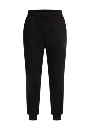 Pantalones de chándal negros hechos de tela suave, con cinturilla elástica, bolsillos laterales y puños acanalados. Diseño simple con un pequeño detalle de logo.