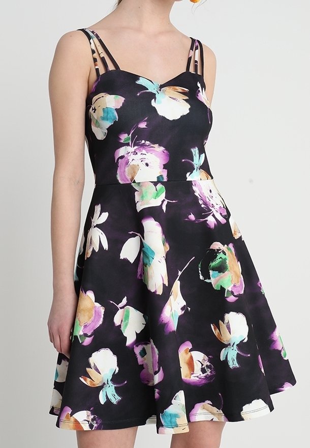 Černé bezrukávové šaty s rozšířenou sukní, zdobené barevnými květinovými vzory v růžové, zelené a bílé barvě. Vybavené tenkými ramínky.