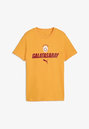 Gul t-shirt med korte ærmer med teksten Galatasaray, klublogo med fem stjerner og Puma-logo trykt i mørkerød på fronten.