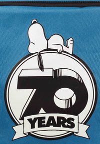 Blaues Stoffbeutel mit einer Grafik von Snoopy, der auf einer schwarz-weißen 70 liegt, mit "JAHRE" auf einem Banner darunter.