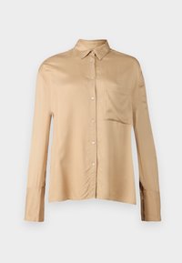 Beige sidenkjorta med knäppning fram, krage och en bröstficka. Långa ärmar med knäppta manschetter. Slät textur.
