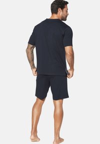 Set aus kurzärmeliger, navyblauer Baumwoll-T-Shirt und Shorts. Das T-Shirt hat einen Rundhalsausschnitt, während die Shorts einen elastischen Bund haben.