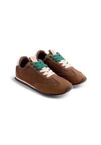 Baskets en daim marron avec un design perforé, lacets verts et beiges, semelle en caoutchouc noir avec une bande rouge. Forme de bout arrondi.