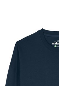 T-shirt bleu marine à col rond avec des coutures visibles et une étiquette en coton biologique imprimée à l'intérieur de la zone du col.