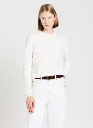 Pull en tricot blanc avec col rond et manches longues, associé à un pantalon blanc et une ceinture marron foncé. Design simple et texturé.