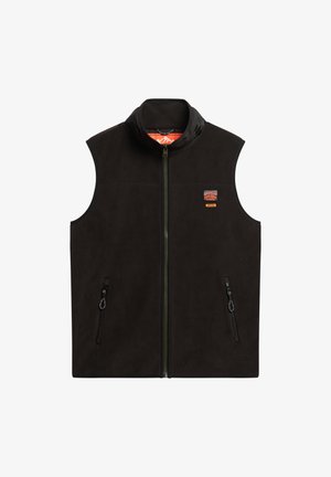 Zwarte fleece vest met hoge kraag, ritssluiting aan de voorkant en twee zijzakken met rits. Bevat een logo-patch op de linkerborst. Soepele textuur.