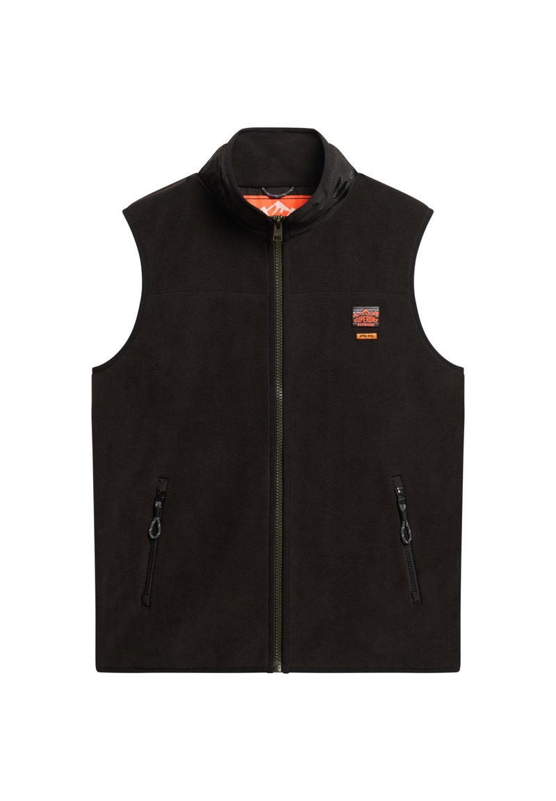 Gilet en polaire noir avec col haut, fermeture éclair avant et deux poches latérales zippées. Présente un insigne brodé sur le côté gauche de la poitrine. Texture lisse.