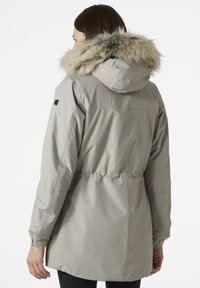 Light grey parka jacket with a faux fur hood, cinched waist, side pockets, and a smooth, water-resistant fabric texture.