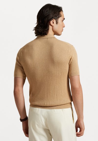 Μπλουζάκι με κοντά μανίκια, πλεχτό από λεπτή ύφανση και με ριμπ φόδρα. Χωρίς ραφές, εφαρμοστό σχέδιο, σε συνδυασμό με ανοιχτόχρωμο παντελόνι.