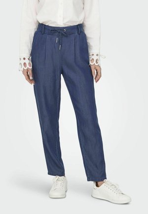 Denim trousers in dark blue with a tapered fit, featuring a drawstring waist and side pockets, paired with white sneakers.