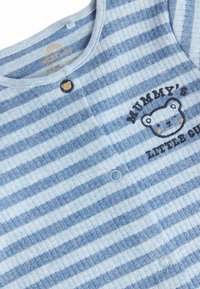 Striped blue and white sleep suit made of soft fabric, featuring a bear graphic and the text "Mummy's Little Cub," with snap buttons.
