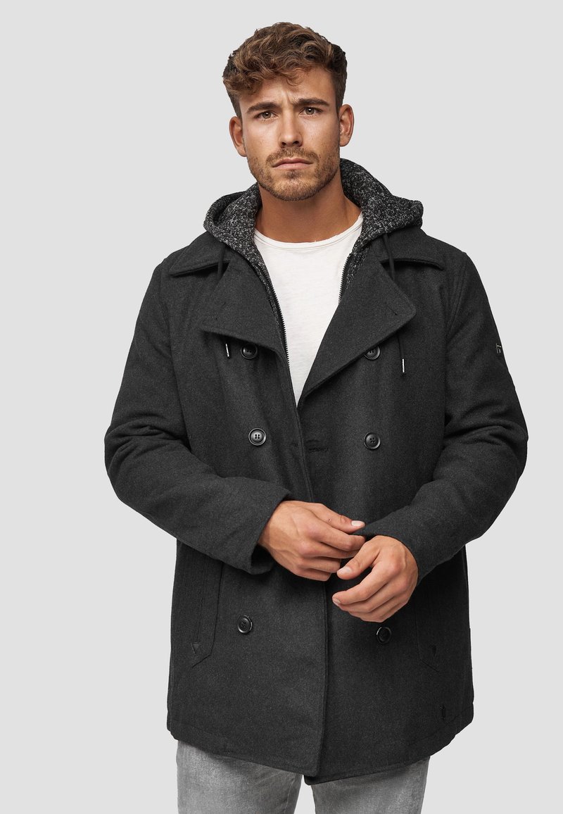 Svart dobbeltspent frakk med en teksturert grå hette og store knapper; har en avslappet passform og sidelommer.