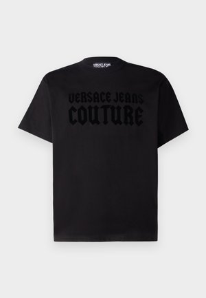 Black cotton t-shirt featuring a crew neckline and short sleeves. The front displays a raised logo "VERSACE JEANS COUTURE" in tonal lettering.