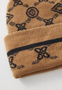 Gorro de punto en marrón con patrones negros, que presenta diseños intrincados y un puño enrollado. Fabricado con un material suave y texturizado.