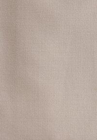 Tissu uni beige clair avec une fine texture tissée et de légers plis.