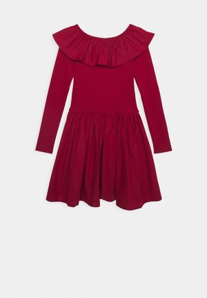 Robe en coton rouge à manches longues, présentant un col froncé et une jupe évasée. Texture lisse et détail de taille froncée.