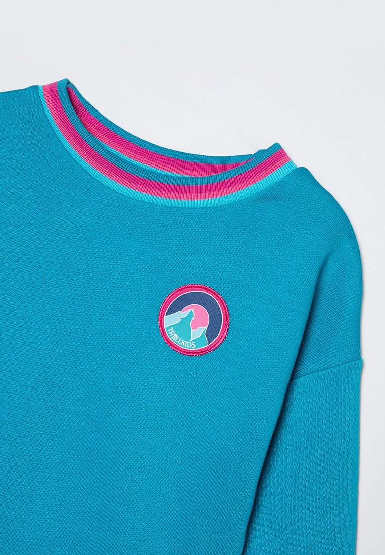 Türkiser Sweatshirt mit einem runden Logopatch, das Hände im Kreis zeigt, akzentuiert durch einen mehrfarbigen gerippten Halsausschnitt in Pink und Blau.