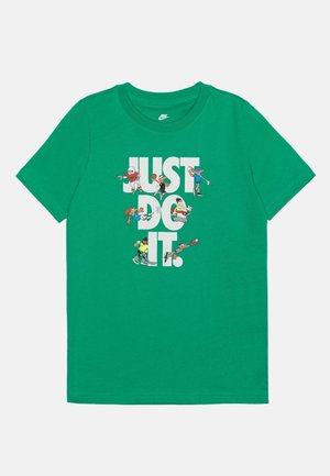 Zielona koszulka Nike z napisem "JUST DO IT." z postaciami z kreskówek grającymi w piłkę nożną, koszykówkę, golfa, piłkę nożną i baseball.