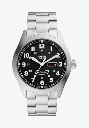 Zegarek słoneczny Fossil z czarną teksturowaną tarczą, srebrną bransoletą ze stali nierdzewnej, białymi znacznikami godzin oraz wyświetlaczem daty na 18.