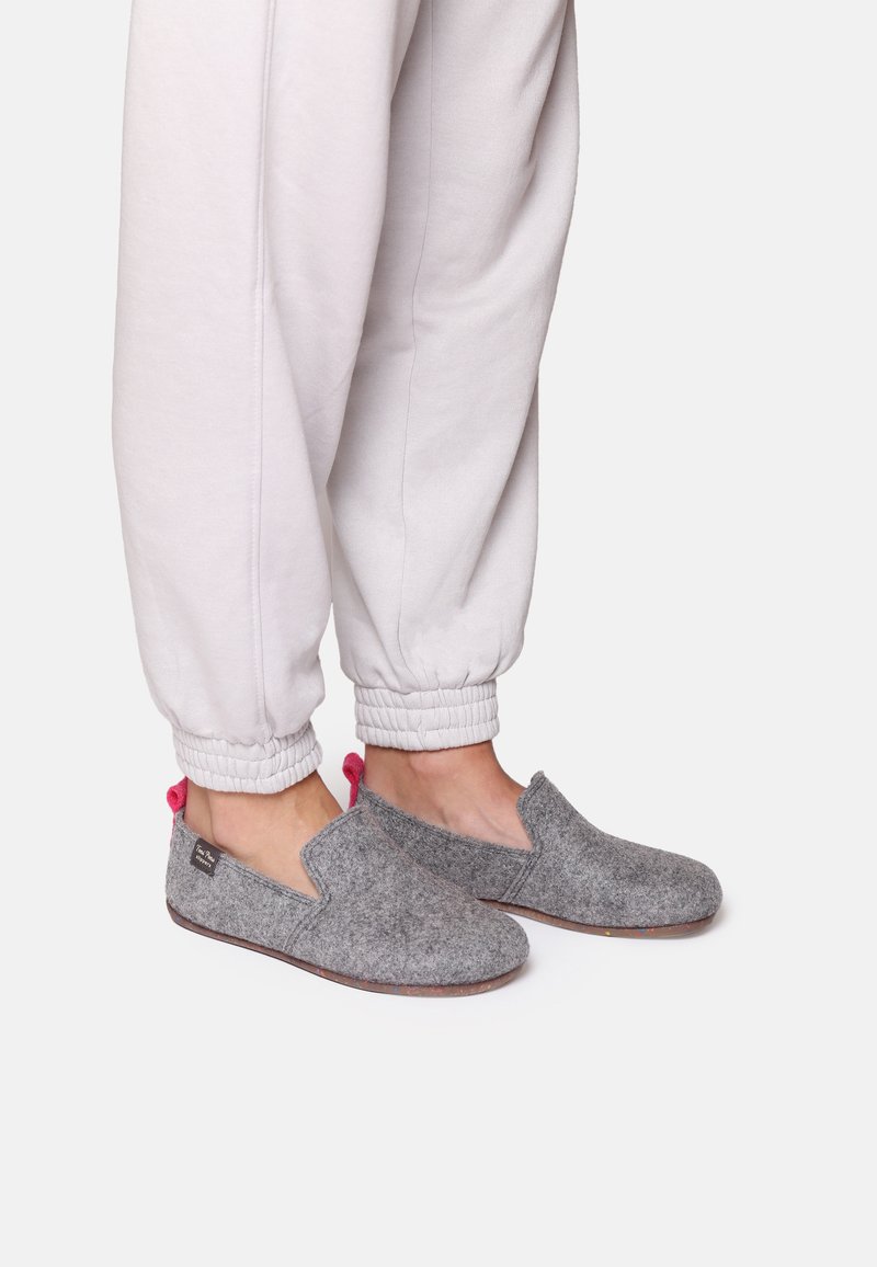 Gray felt slip-on shoes with a round toe and pink accents, paired with light gray jogger pants with elastic cuffs.