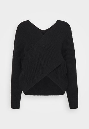 Sort ribstrikket sweater med lange ærmer og et bredt krydset frontdesign, vist på en enkel lys baggrund.