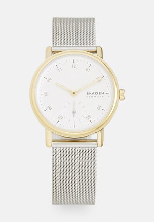 Goldfarbene runde Uhr mit einem weißen Ziffernblatt, dünnen Stundenmarkierungen und zwei Zeigern. Silbernes Mesh-Armband mit einem sicheren Verschluss. Hilfszifferblatt um sechs Uhr.
