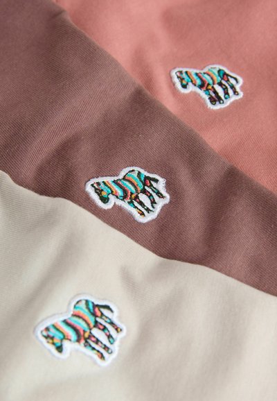 Drei überlappende Stoffabschnitte in Rosa, Braun und Creme, jeweils mit einer bunten gestreiften Zebra-Stickerei. Glatte Textur.