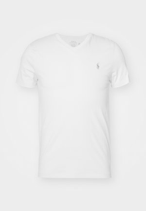 T-shirt bianco a V in cotone, con un piccolo logo ricamato sul lato sinistro del petto. Maniche corte e vestibilità rilassata.