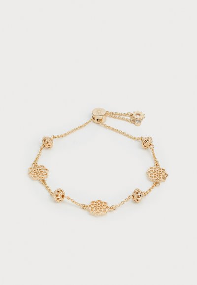 Gold bracelet featuring multiple floral-shaped charms with intricate cut-out patterns, linked by a delicate chain. Adjustable with a clasp.