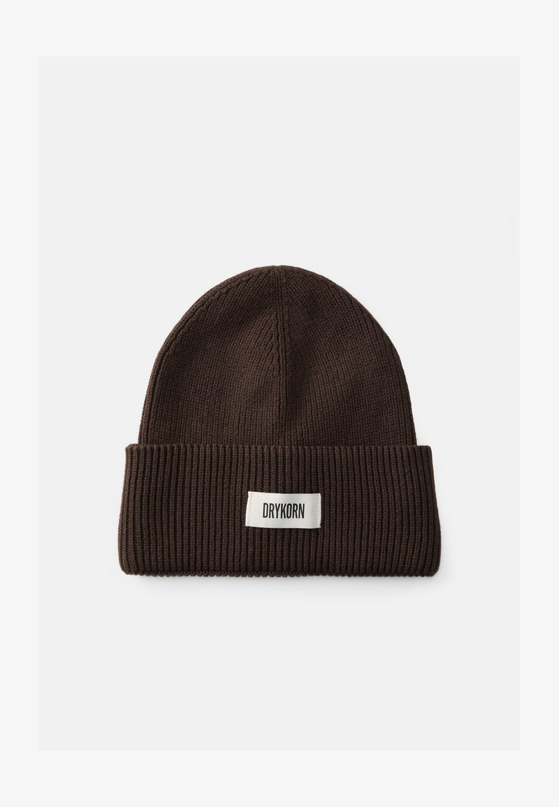 Brūns adīts beanie ar ribotu tekstūru, kas satur salocītu aproci un baltu etiķeti ar zīmola nosaukumu "DRYKORN."