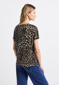 Top a maniche corte con stampa animalier in tonalità di marrone e nero, caratterizzato da una vestibilità comoda e scollatura rotonda, realizzato in tessuto morbido.