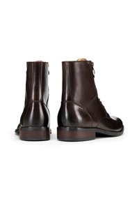 Hnědé kožené kotníkové boty s kulatou špičkou, šněrovacím designem a dřevěnými podpatky; hladký povrch a minimální šití.