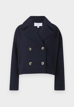 Marineblå kort jakke med dobbeltknapp, med krage, som har to frontlommer og messingknapper, laget av et mykt stoff.