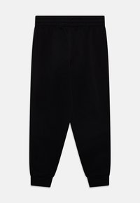 Černé tepláky s elastickým pasem a manžetami na kotnících, zobrazené vodorovně na bílém pozadí.