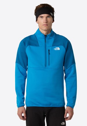 Pullover in fleece blu con colletto alto, mezza zip e tasca sul petto. Presenta pannelli a contrasto e un logo sul lato sinistro del petto.