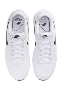 Witte Nike Air sneakers met meshpanelen en zwarte accenten. Kenmerken zijn onder andere platte veters, een gevoerde tong en een gestructureerde zool.